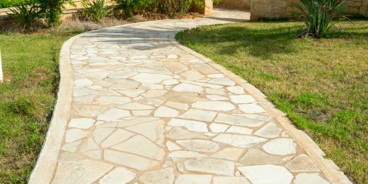 An intricately designed decorative concrete stone pathway winds gracefully through the landscape