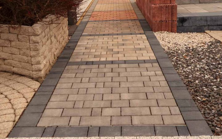 Elegantly arranged decorative concrete pavers featuring darker hues along their edges, creating a sophisticated border that frames the pathway with subtle contrast.