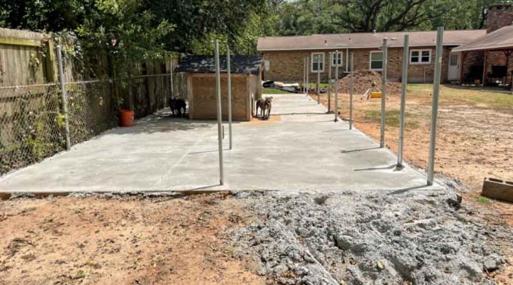 Ongoing construction of a concrete backyard patio with metal columns