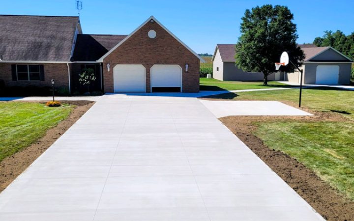 Resurfaced Concrete Driveway of a house with a wide lawn, for a cleaner look and enhanced durability